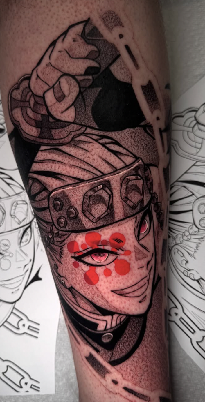 Black and grey anime character forearm tattoo with red accent detail